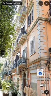 a building with balconies and a sign in front of it at Appartamento politeama Palermo in Palermo