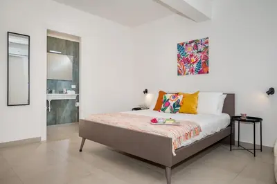 a bedroom with a bed and a painting on the wall at Villa Maria con piscina e vista mare 12 posti letto in Castellammare del Golfo