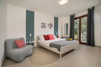 a bedroom with a bed and a chair at Villa Maria con piscina e vista mare 12 posti letto in Castellammare del Golfo