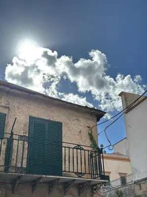 a building with a green door and a balcony at Duomo View Apartment in Monreale