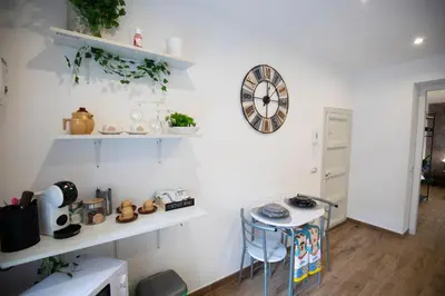 a white room with a table and a clock on the wall at Duomo View Apartment in Monreale