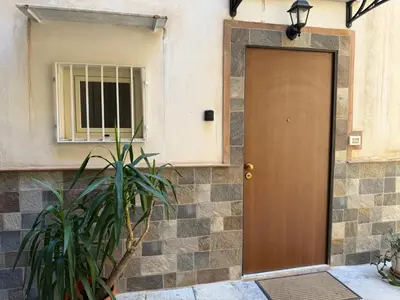a wooden door of a house with a plant at Casa AG in Palermo