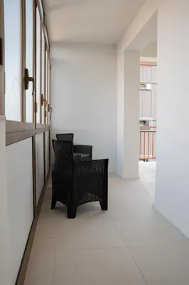 a hallway with two black chairs in a building at Duecento Rooms in Palermo