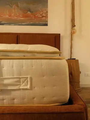a bedroom with a bed with a wooden frame at Dimidia - casa vacanze mare montagna in Capaci