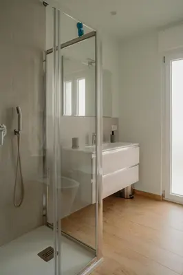 a glass shower in a bathroom with a sink at Sarina's apartment in Palermo