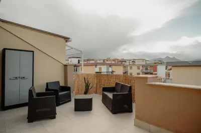 a balcony with two black chairs on a roof at Sarina's apartment in Palermo