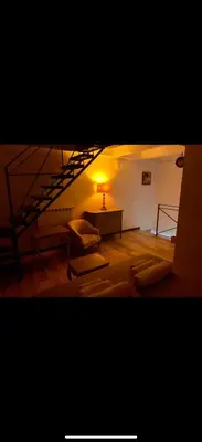 a living room with a table and a lamp at Al rifugio della stazione in Palermo