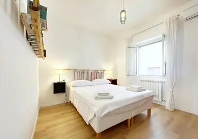 a white bedroom with a bed and a window at Solemar Sicilia - Casa Sabine in Santa Flavia
