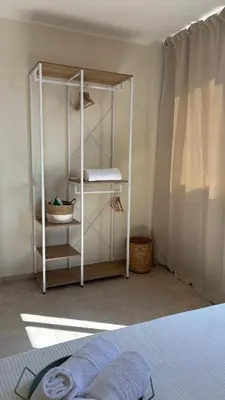 a bedroom with a white shelving unit in a room at Ciàuru di mari Mondello apartment and terrace in Palermo