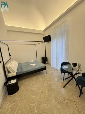 a bedroom with a bed and a chair and a table at Palermo Central Rooms in Palermo