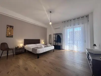 a bedroom with a bed and a desk and a window at Casa Mama in Palermo