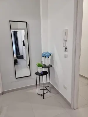 a mirror and a table with flowers in a room at Sasi Home in Terrasini