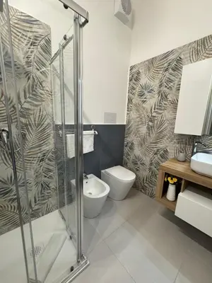 a bathroom with a shower and a toilet and a sink at Sasi Home in Terrasini