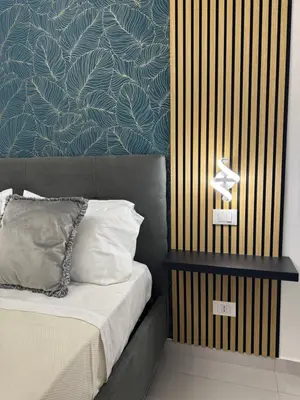 a bedroom with a bed with a blue and gold wall at Sasi Home in Terrasini