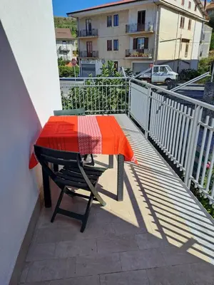 a table with an orange and red blanket on a balcony at ANGELA Rooms in Marineo