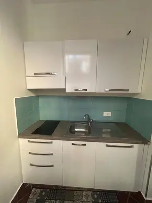 a kitchen with white cabinets and a sink at Tinchitè - A due passi dal Teatro Massimo in Palermo