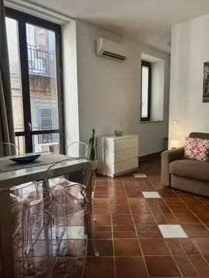 a living room with a table and a couch at Tinchitè - A due passi dal Teatro Massimo in Palermo