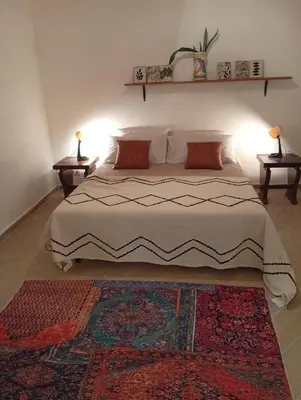 a bedroom with a bed with two tables and a rug at Casetta Professa Centro in Palermo