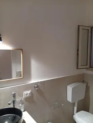 a bathroom with a sink and a toilet and a mirror at Casetta Professa Centro in Palermo