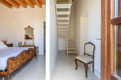 a bedroom with a bed and a ladder and a chair at San Salvatore Apartment by Wonderful Italy in Palermo