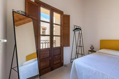 a bedroom with a bed and a large wooden door at San Salvatore Apartment by Wonderful Italy in Palermo