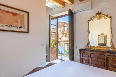 a bedroom with a bed and a mirror on a dresser at San Salvatore Apartment by Wonderful Italy in Palermo