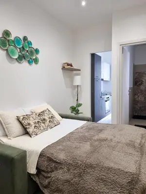 a bedroom with a large bed and a kitchen at A' meusa Palermo Historic Center Check-in 24h in Palermo