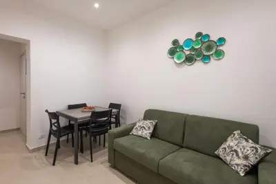 a living room with a green couch and a table at A' meusa Palermo Historic Center Check-in 24h in Palermo