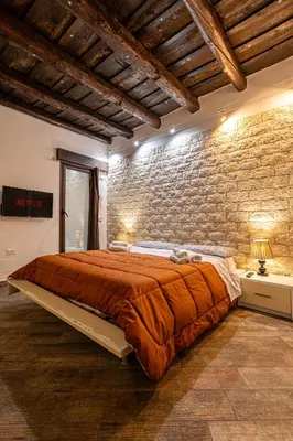 a bedroom with a brick wall and a large bed at Casa Ambra in Palermo