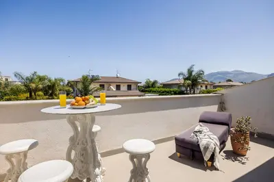 a table with a bowl of fruit on a balcony at Elegant Villa With Pool Luxury in Carini