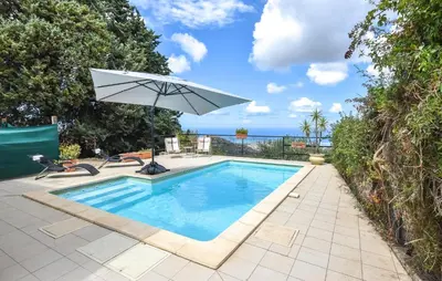 a swimming pool with an umbrella and a chair and a table at Amazing Home In Caccamo in Caccamo