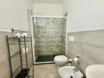 a bathroom with a shower and a toilet and a sink at Dimora Sant'Agostino in Palermo