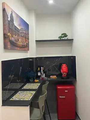 a kitchen with a table and a red refrigerator at La Suite del Viaggiatore in Palermo