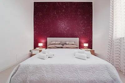 a bedroom with a large white bed with two lamps at CastroViva House in Palermo
