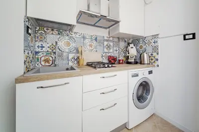 a kitchen with a sink and a washing machine at CastroViva House in Palermo