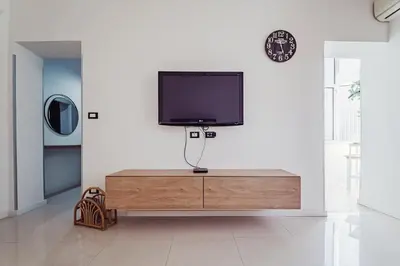 a flat screen tv sitting on top of a wooden cabinet at CastroViva House in Palermo