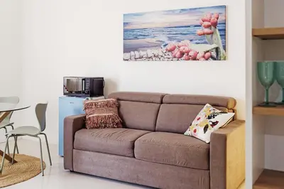 a living room with a couch and a painting on the wall at CastroViva House in Palermo