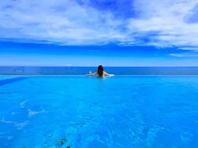 a woman sitting in the water in the ocean at Sunset in Santa Flavia