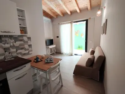 a kitchen and living room with a couch and a table at Casetta Giardinetto in Altavilla Milicia