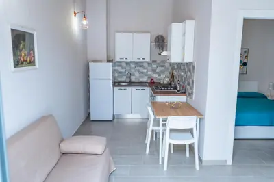 a small kitchen with a table and a couch at Casetta Giardinetto in Altavilla Milicia