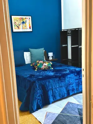 a bedroom with blue walls and a bed with a bluespread at Casa Amuri in Palermo