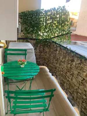 a green table and chairs on a patio with a stone wall at Girasole Marino in Palermo