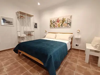 a bedroom with a bed with a blue blanket at Esperia Home in Palermo