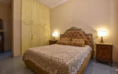 a bedroom with a bed and two lamps and a dresser at Cozy Apartment In Trappeto With Wifi in Trappeto