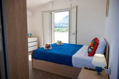 a bedroom with a bed with a large window at Villa Verde - Nature Holiday Home in Carini