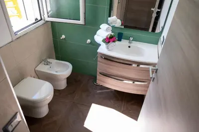 a bathroom with a toilet and a sink and mirror at Villa Verde - Nature Holiday Home in Carini