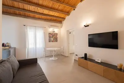 a living room with a couch and a flat screen tv at Cathedral Apartment - Stay in Palermo in Palermo