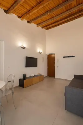 a living room with a television and a couch at Cathedral Apartment - Stay in Palermo in Palermo