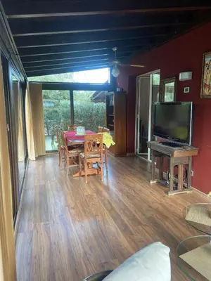 a living room with a table and a television at Il Giardino di Seba in Campofelice di Roccella