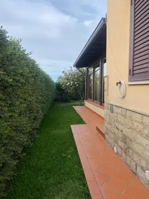 a house with a brick walkway next to a building at Il Giardino di Seba in Campofelice di Roccella